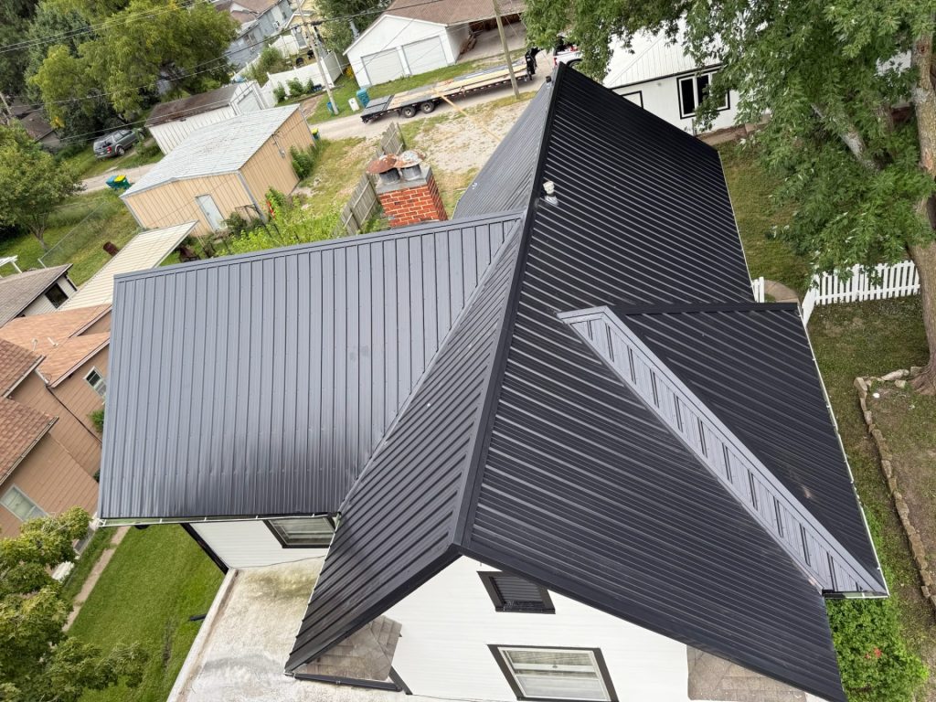 Two-story house with a newly installed black metal roof, likely completed by KM Roofing Solutions LLC.